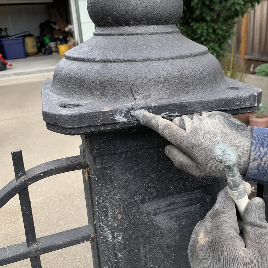 professional repairing a cracked metal gate post with epoxy
